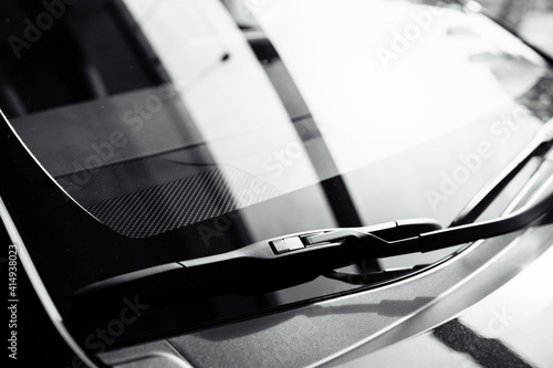 close up of front Windshield Wipers on a black new car in salon.
