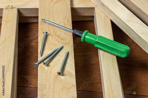 Woodwork. Wooden slats and working tools. Metal screw and screwdriver.