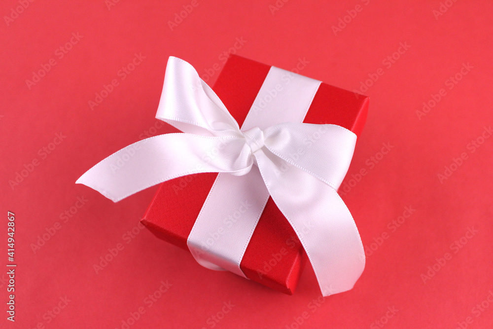 Red gift box with white ribbon on red background Red gift box with white ribbon on red background
