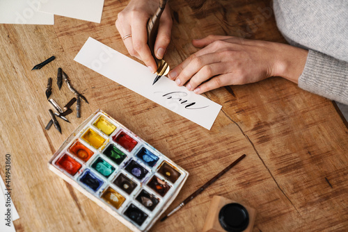 Photography Calligrapher girl writing while working at table indoors