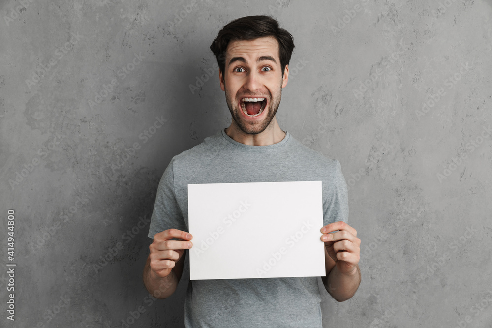 Handsome young man with a white blank board isolated Handsome young man with a white blank board isolated