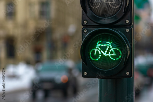 Sustainable transport. Bicycle traffic signal, green light, road bike, free bike zone or area, bike sharing, close up with street and car on background
