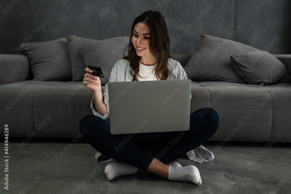 Happy smiling woman sitting on couch and using laptop Happy smiling woman sitting on couch and using laptop