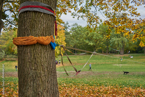 Volkspark Hasenheide, Befestigung einer Slackline an einem Baum, Mann balanciert auf Slackline, Bäume mit Herbstlaub,  Neukölln, Berlin, Deutschland photo