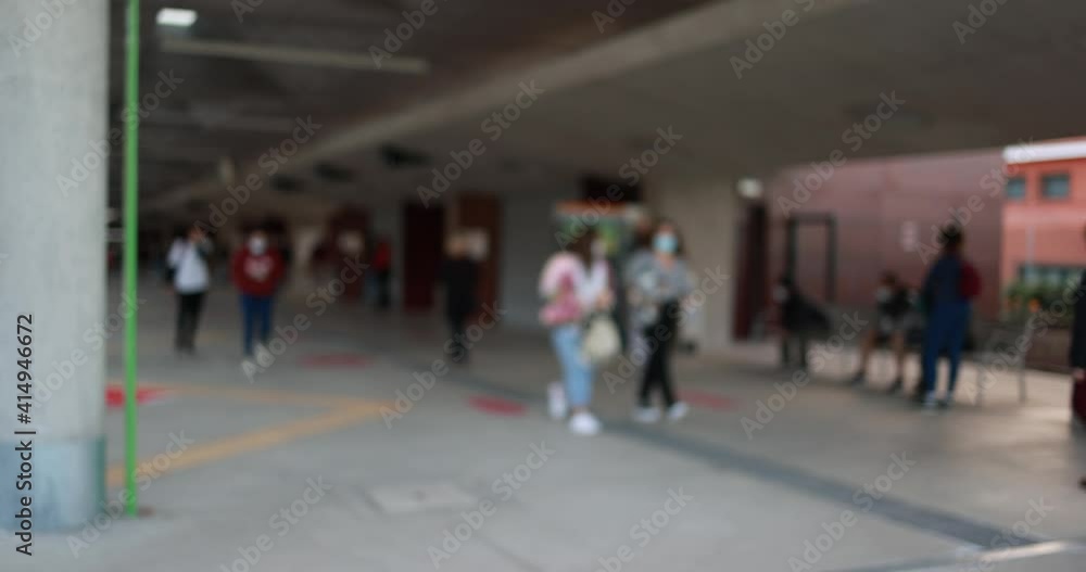 Blurred people walking at bus station wearing safety mask for coronavirus outbreak - Defocused video