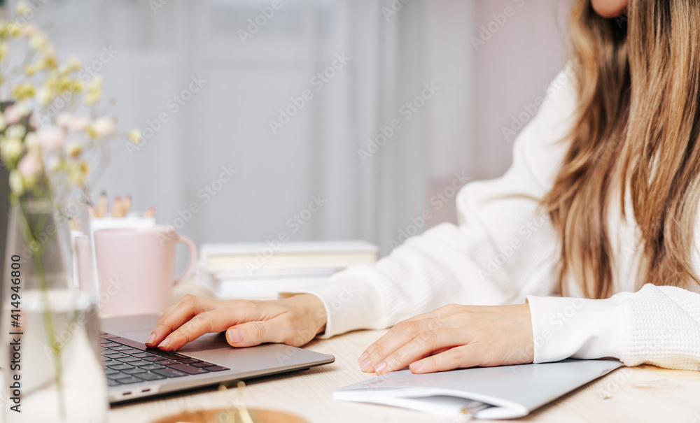 Fototapeta premium Distance learning online education and work. Business woman writes goals, plans, make to do and wish list in notebook on desk, working from home office. Using laptop.