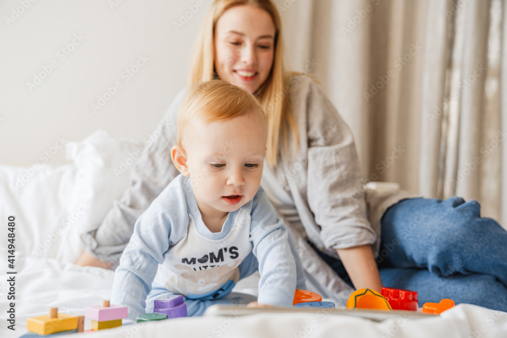 Young mother playing with her baby son at home Young mother playing with her baby son at home
