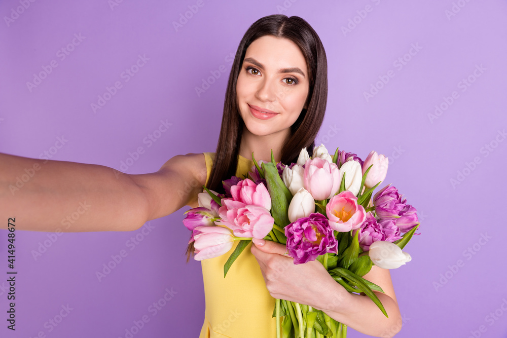 Self-portrait of attractive cheerful girl holding hugging tulips festal occasion isolated over violet purple pastel color background Self-portrait of attractive cheerful girl holding hugging tulips festal occasion isolated over violet purple pastel color background