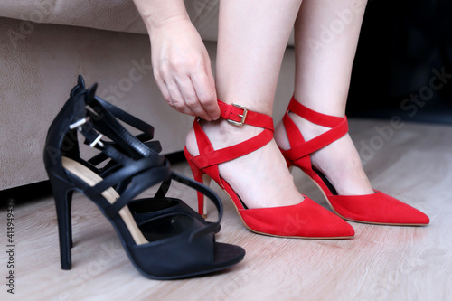 Woman fitting red and black shoes on high heels. Ladies fashion and footwear, shopping, health of the feet