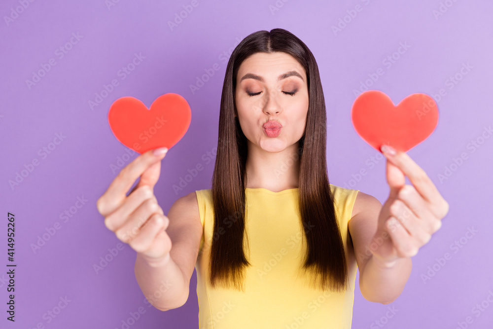 Portrait of attractive affectionate girl holding in hands two heart form sending air kiss isolated over violet purple pastel color background Portrait of attractive affectionate girl holding in hands two heart form sending air kiss isolated over violet purple pastel color background