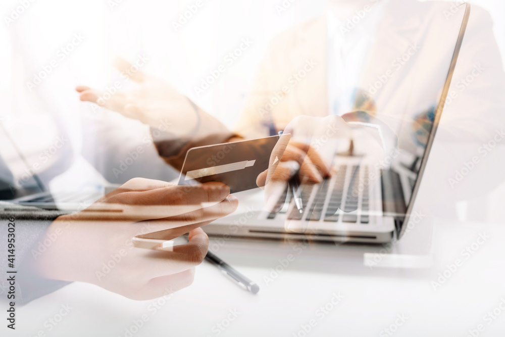 Fototapeta premium businesswoman hand using smart phone, tablet payments and holding credit card online shopping, omni channel, digital tablet docking keyboard computer at office in sun light