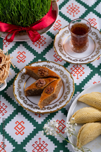 Novruz pastry pakhlava, Azerbaijan national holiday, ethnic cuisine eastern desserts for spring equinox celebration in white and golden plate. Persian nooruz sweets, copy space 
