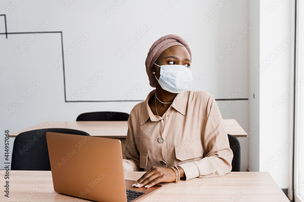 African black woman with laptop. Using computer for on-line work. Medical mask for protection against coronovirus covid-19. African black woman with laptop. Using computer for on-line work. Medical mask for protection against coronovirus covid-19.