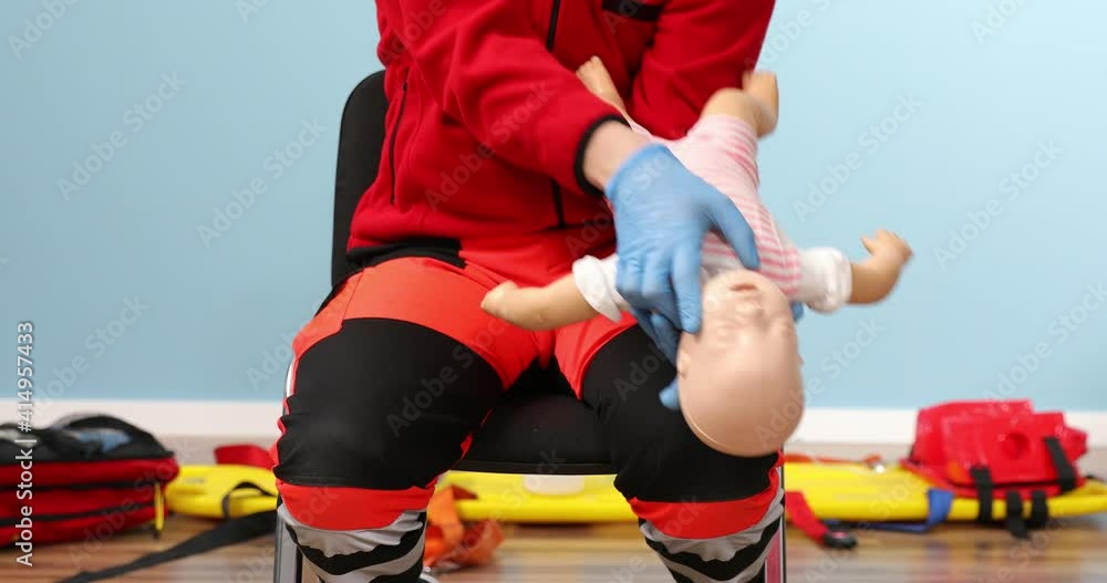 Close up, instructor performs CPR on baby training doll. First aid ...