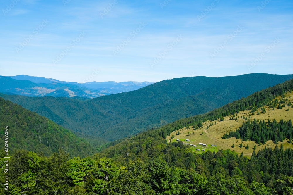 Mountain landscape with wooden shepherd's huts in the Carpathians, Ukraine. Local tourism concept. Copy space. Mountain landscape with wooden shepherd's huts in the Carpathians, Ukraine. Local tourism concept. Copy space.