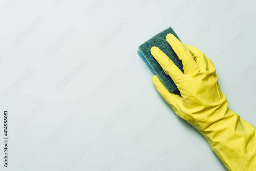 yellow rubber glove is holding sponge on the white background. yellow rubber glove is cleaning with sponge yellow rubber glove is holding sponge on the white background. yellow rubber glove is cleaning with sponge