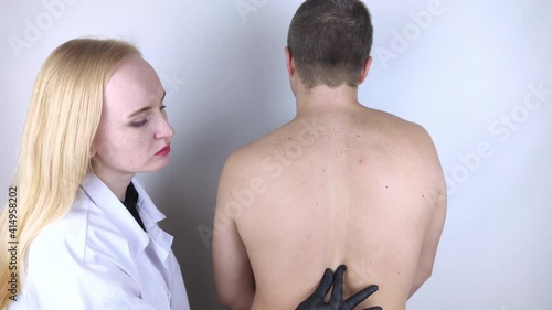 A man at the doctor's appointment with back pain. Treatment of spinal deformity and stoop. Osteoporosis, kyphosis, lordosis, or scoliosis. photo