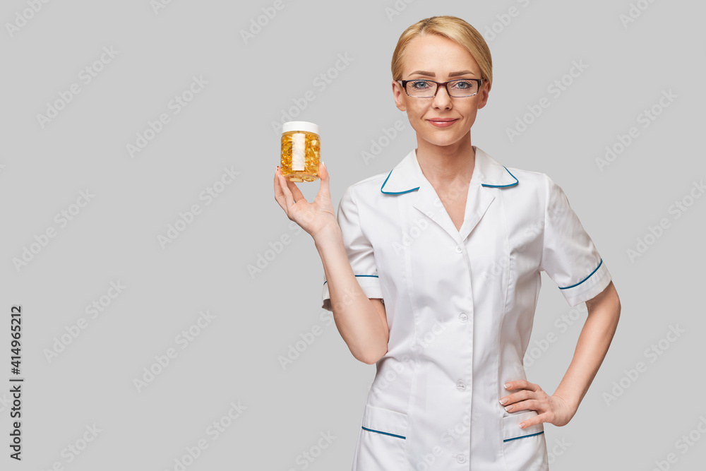Health care and diet concept - doctor nutritionist or cardiologist holding fish oil in capsules for vitamin D and omega-3 fatty acids Health care and diet concept - doctor nutritionist or cardiologist holding fish oil in capsules for vitamin D and omega-3 fatty acids