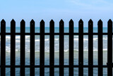 silhouette wooden fence with wavy blue sea behind