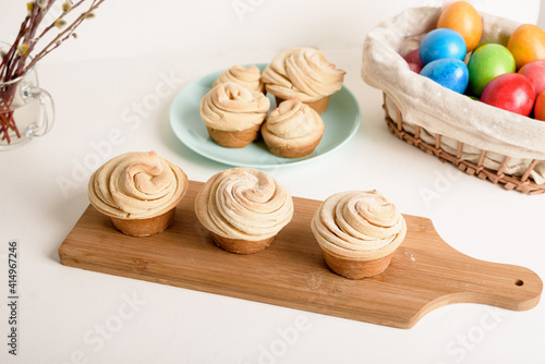 cruffins easter spring pastries  a mixture of muffin and croissant on a light background  the composition Easter painted eggs willow and cake