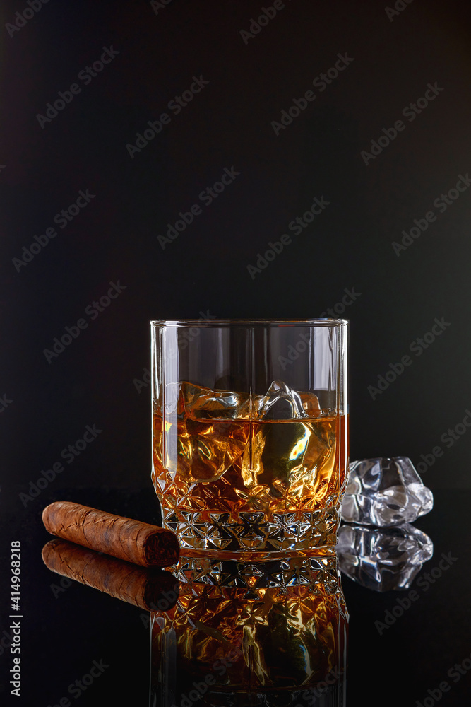 Whiskey with ice or brandy in glass with cigar on black background. Whisky  with ice in glass. Whiskey or brandy. Selective focus. Stock-Foto | Adobe  Stock