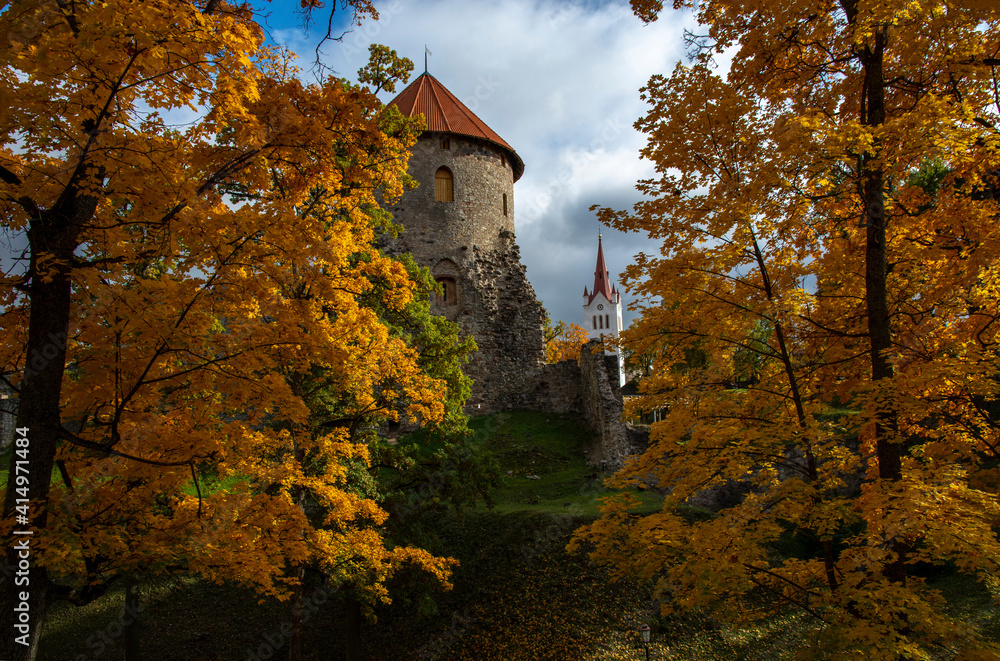 old castle in the autumn park landscape with blue sky and clouds 