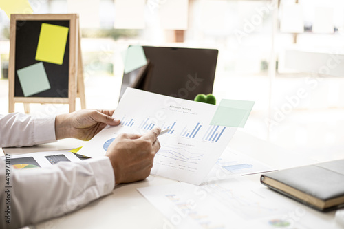 The chief finance officer is reviewing the company's financial chart documents before meeting with the management for presentation, he checks the accuracy of the documents produced by the finance team