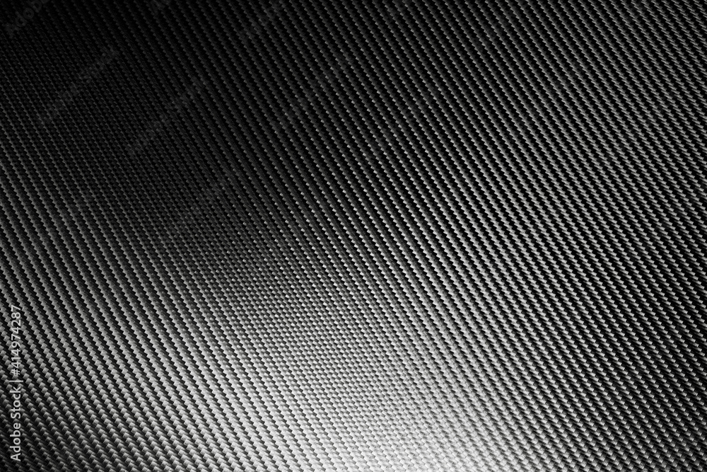 Bended surface of grey woven carbon fibre composite sheet. Bended surface of grey woven carbon fibre composite sheet.