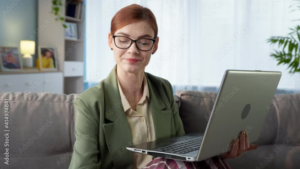 working from home, young business woman wearing eyeglasses in pajamas and jacket talking on video call with client on laptop during quarantine working from home, young business woman wearing eyeglasses in pajamas and jacket talking on video call with client on laptop during quarantine