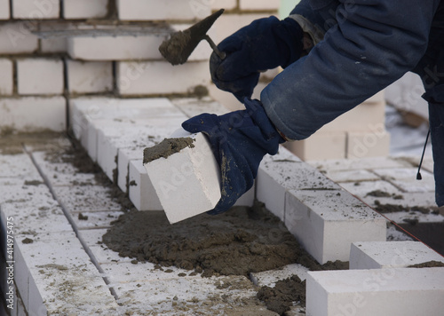 A bricklayer puts bricks in cement, works on the construction of a house.