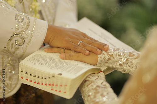 bible and groom hands