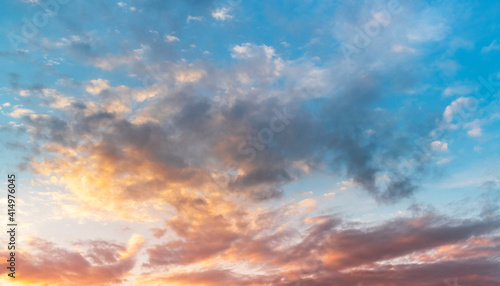 Natural sky background. Bright sunset with orange and blue clouds.