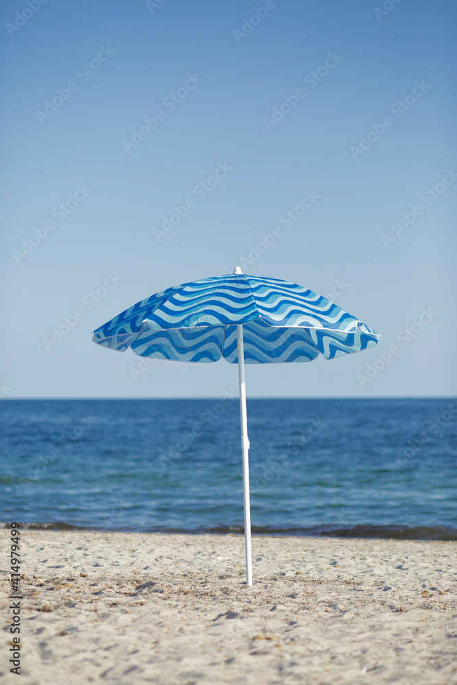 Ombrello singolo piantato in una spiaggia al mare
