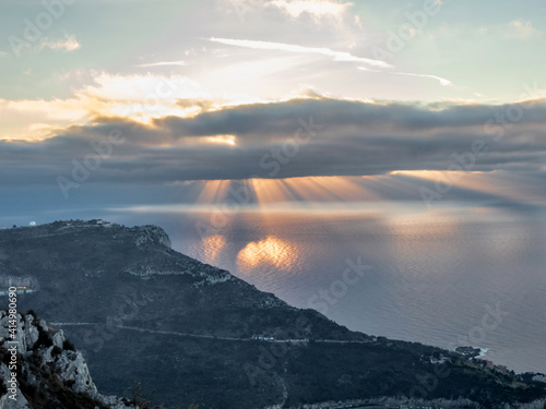 Foto Lever de soleil au-dessus de la mer et rayons de soleil au travers des nuages