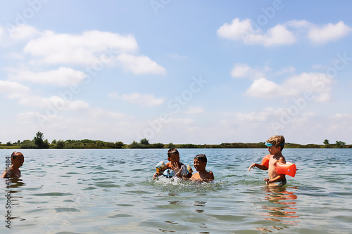 Group of boys having fun in the water during summer day,