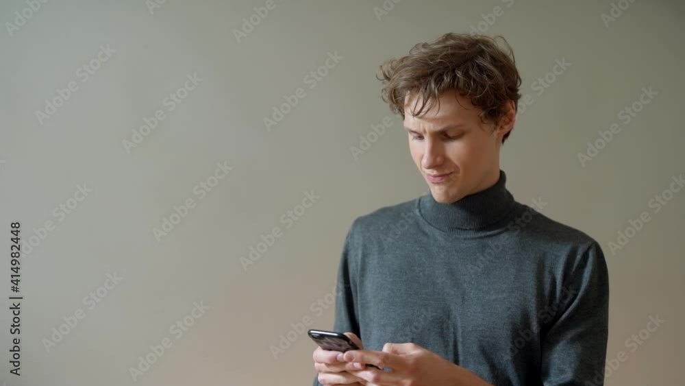Young guy searches on a smartphone and plays different emotions Young guy searches on a smartphone and plays different emotions