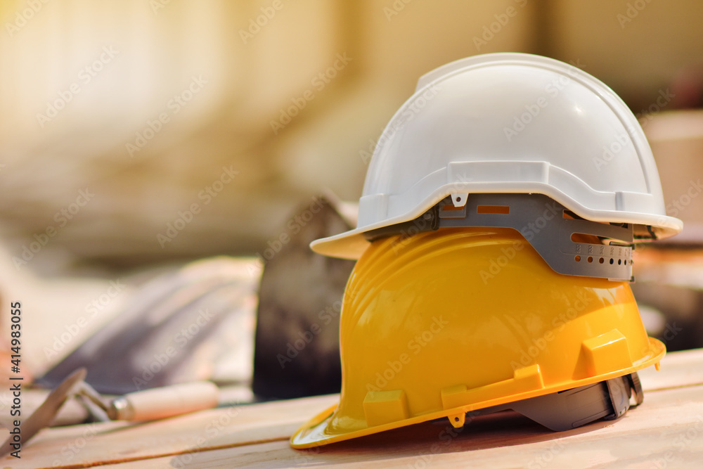 Yellow helmet hard hat on wood floor in constriction site Yellow helmet hard hat on wood floor in constriction site