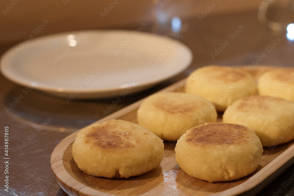 ready fried cheesecakes lie in a plate on a tray on the table the background is blurred