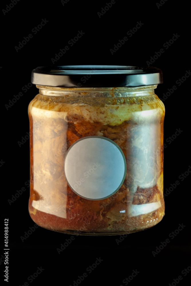 A glass jar with an eco-friendly stew of dark meat on a black background, with a black lid and a small round label in the middle. A glass jar with an eco-friendly stew of dark meat on a black background, with a black lid and a small round label in the middle.