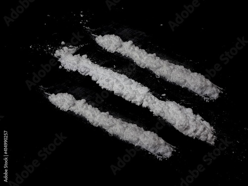 Cocaine drug powder lines on black background