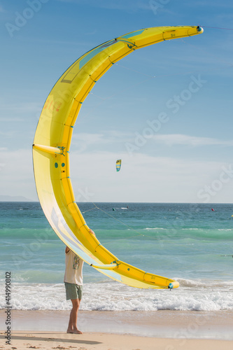 Surfer boy holding Kitesurf kite