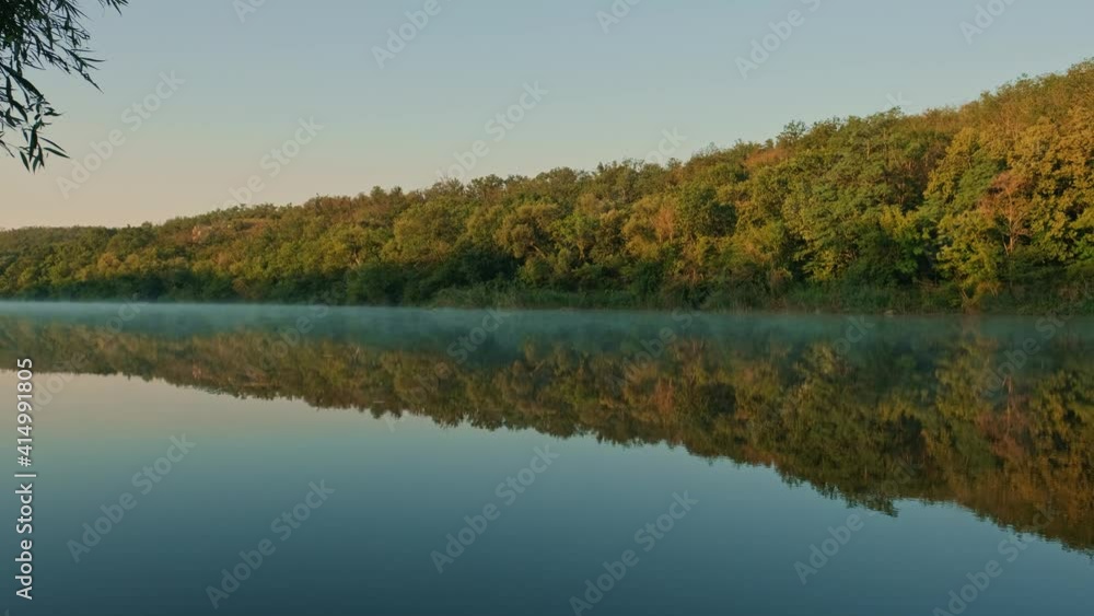 Morning view of river, mountains and forest landscape at foggy sunrise. Flying over water cascade with rock stones. Amazing nature background with lake and blue sky. Beautiful summer nature. Morning view of river, mountains and forest landscape at foggy sunrise. Flying over water cascade with rock stones. Amazing nature background with lake and blue sky. Beautiful summer nature.