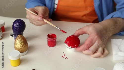 Preparation of props for decorating for Easter. Coloring eggs with paints. Lifestyle.