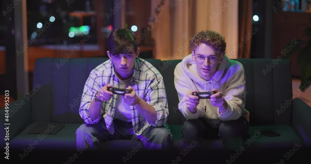 Two caucasian boys polaying online video game winning prize doing high-five. Teamwork concept. Best friends. Home entertainment. Competition. Two caucasian boys polaying online video game winning prize doing high-five. Teamwork concept. Best friends. Home entertainment. Competition.