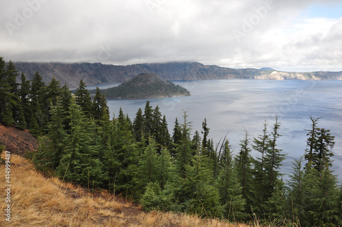Moody view of Wizard Island in Crater Lake National Park on a cloudy day © Jen