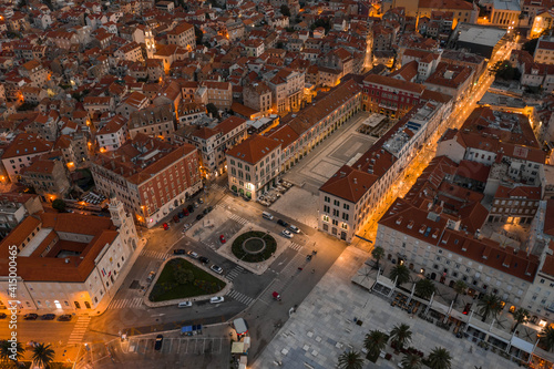 Aerial drone shot of empty republic square by riva with light at dusk in Split old town before sunrise in Croatia