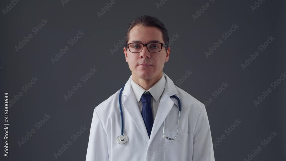 Studio portrait of young professional medical doctor over grey background Studio portrait of young professional medical doctor over grey background