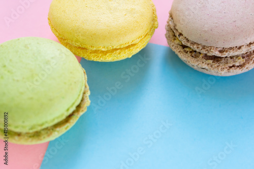 Close up green, yellow and brown cookies in the corner of two colored background with copy space. photo