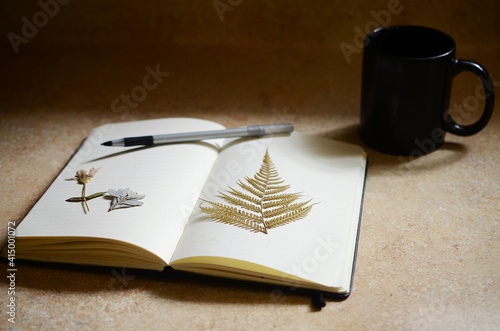 Minimalist desk mockup. Concept of writers journal. Nature meets work desk. Artistic and minimal journaling with dried ferns and natural lighting. 