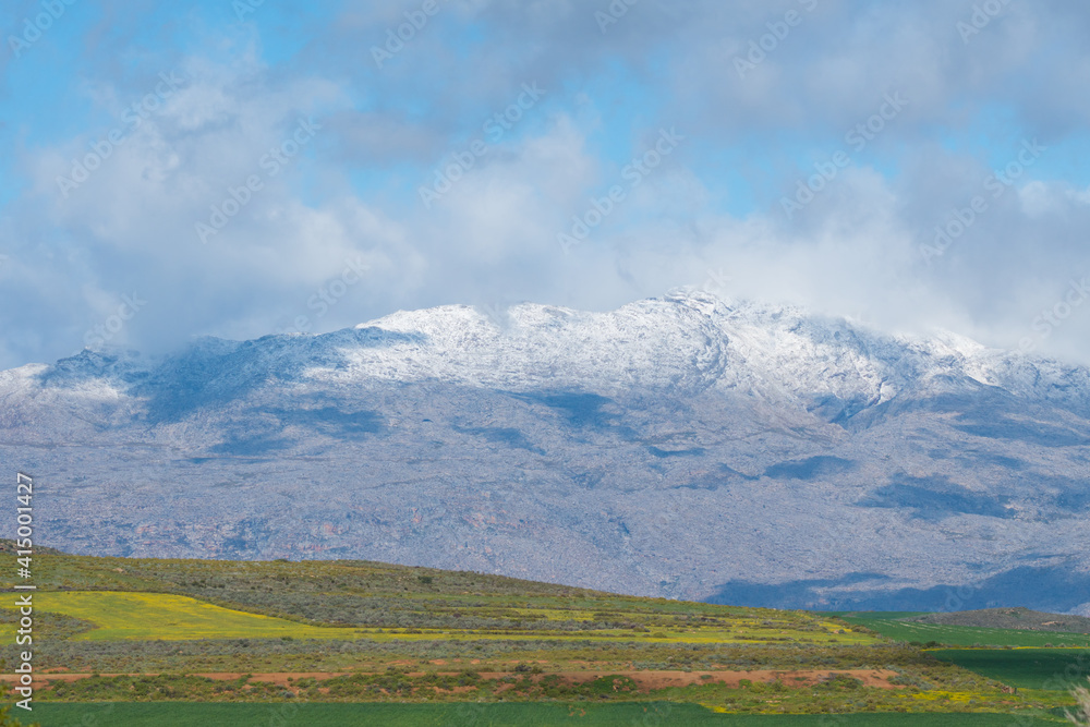 landscape with snow capped mountains and clouds during Winter in Ceres, South Africa 